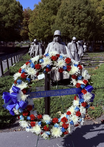 patriotic wreath in front of a Korean War veterans memorial statue