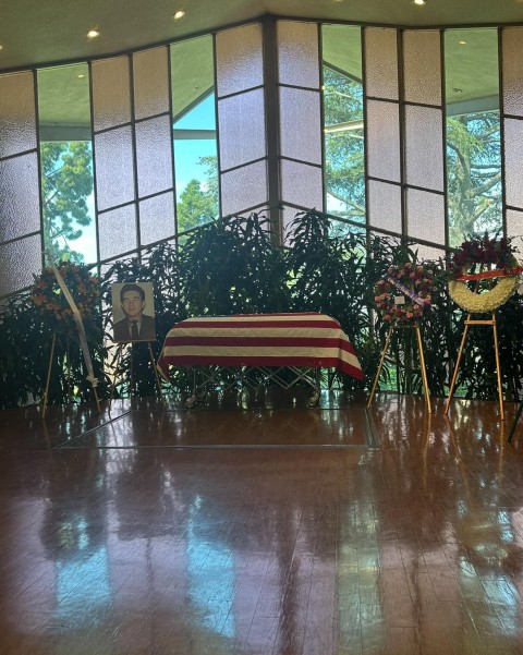 A military casket with memorial photo and flowers